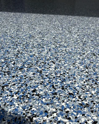 Close-up of blue, black, white and gray flakes in a glossy garage floor.